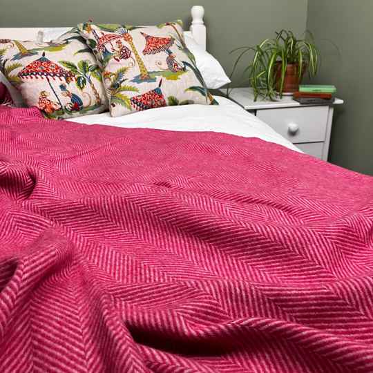 cerise merino wool throw on a bed