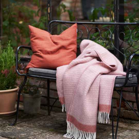 Harald dusty Rose Eco wool throw on a bench