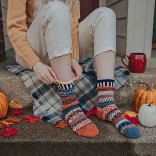 Nutmeg solmate socks worn on feet sat on a step