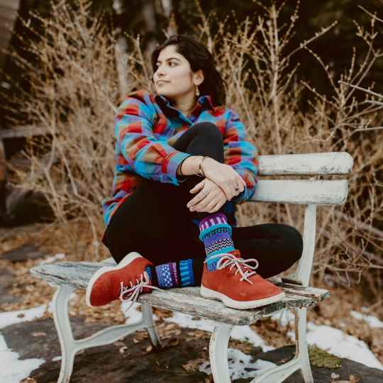 Raspberry solmate socks on a bench being worn