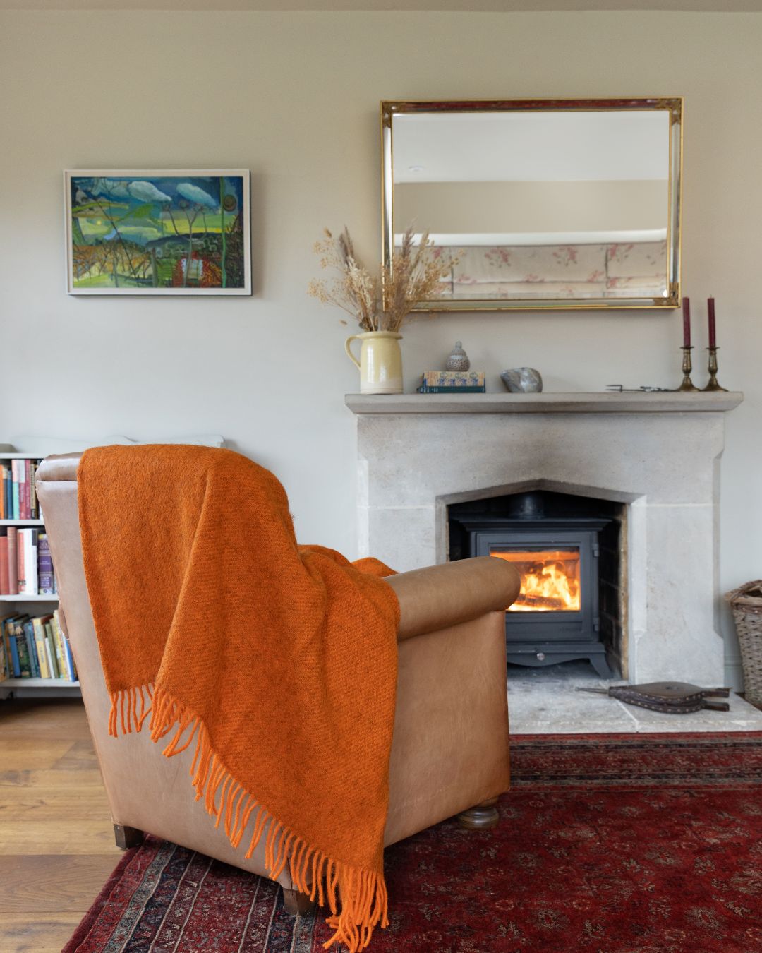 orange gotland wool blanket on a chair with a fire in the background