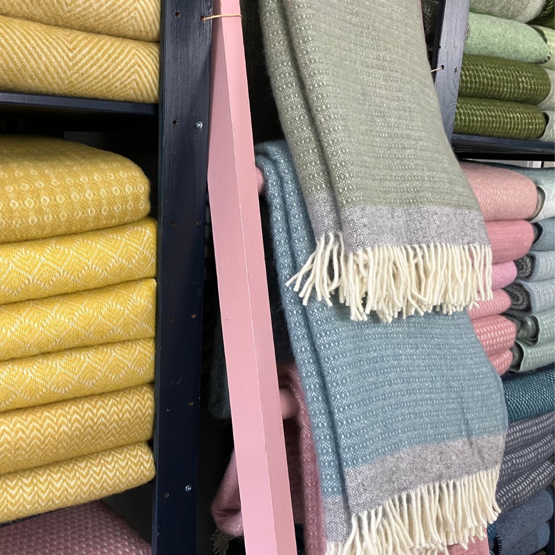 Klippan wool blankets and throws on a shelf and ladder in varoius colours and patterns