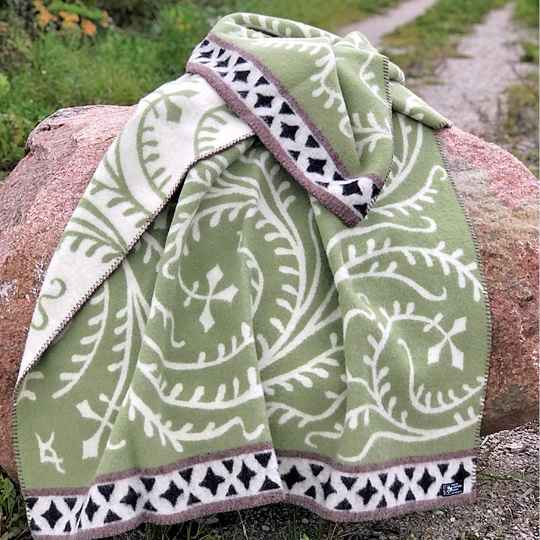 Albertus Green patterned blanket draped over a rock outdoors