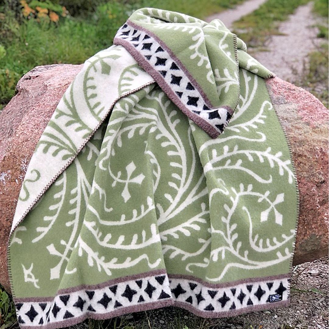Albertus green lambswool throw draped over a rock