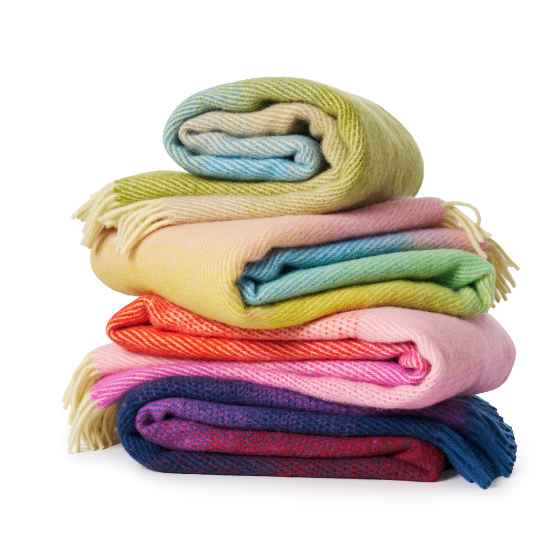 Stack of colorful folded blankets on a white background