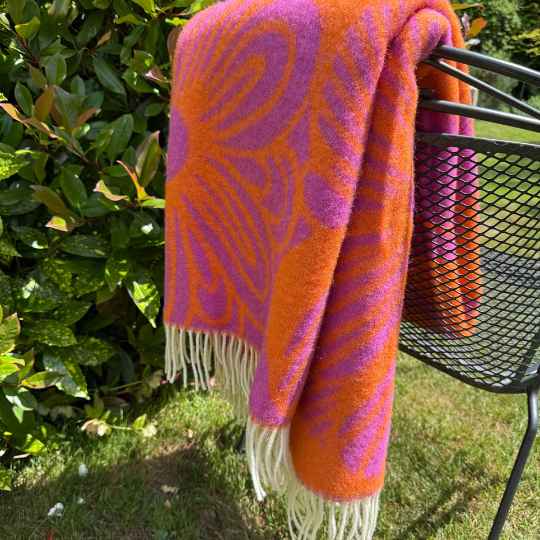 Blomranka cerise and orange wool throw on a chair