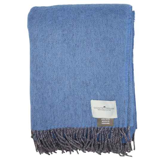 Blue throw blanket with fringes and a visible brand label on a white background