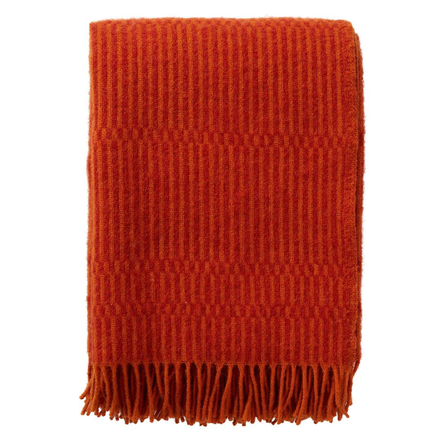 A folded orange-red woven throw blanket with a ribbed texture and fringed edge, shown on a plain white background.