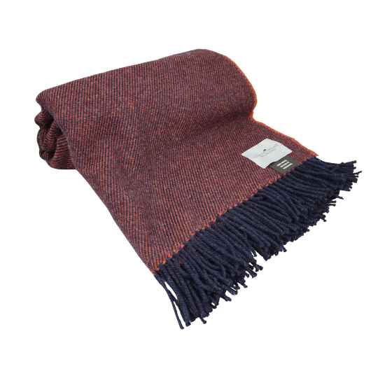 burnt terracotta wool throw rolled up against a white background