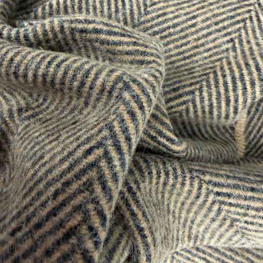 Close-up of wool throw with a herringbone pattern in brown and black tones.