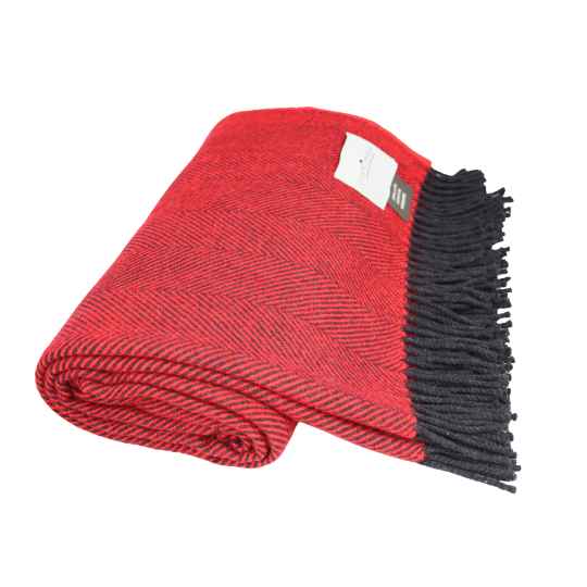 Folded red blanket with black fringe on a white background