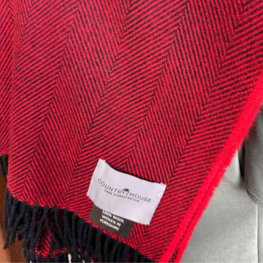 Red woven fabric with a visible label on a gray surface