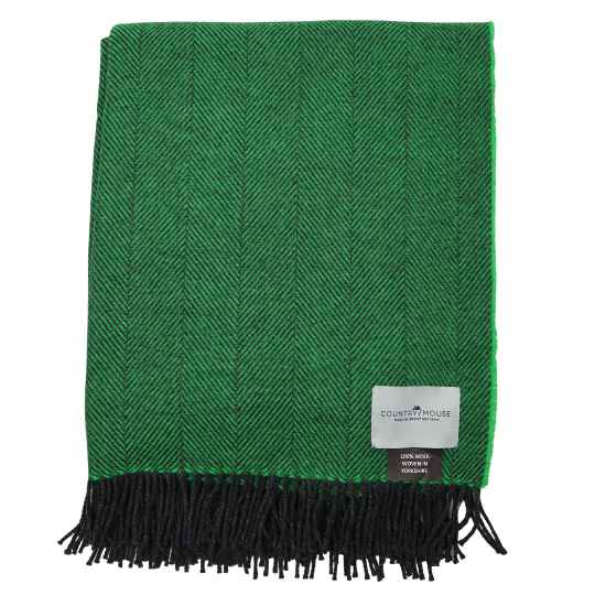 Green herringbone blanket with black fringe on a white background