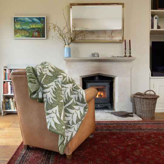 House in the forest on a arm chair with a lit log burner