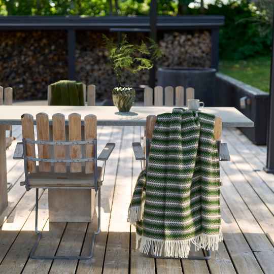 oscar multi green wool throw on the back of a wooden chair