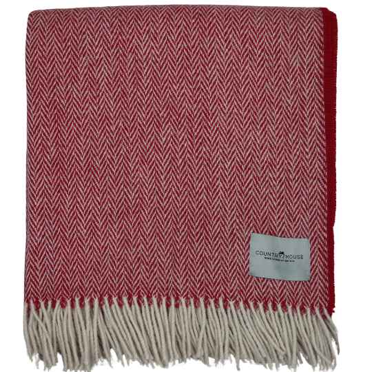 Red and white herringbone patterned throw blanket with a brand label on a white background