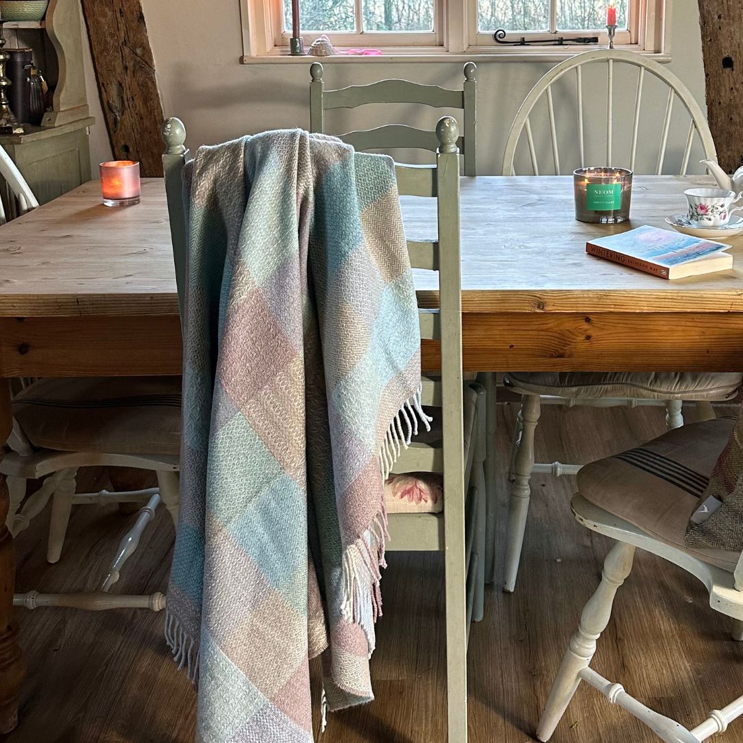Sea Breeze Merino Wool Throw on a dining chair by a table.