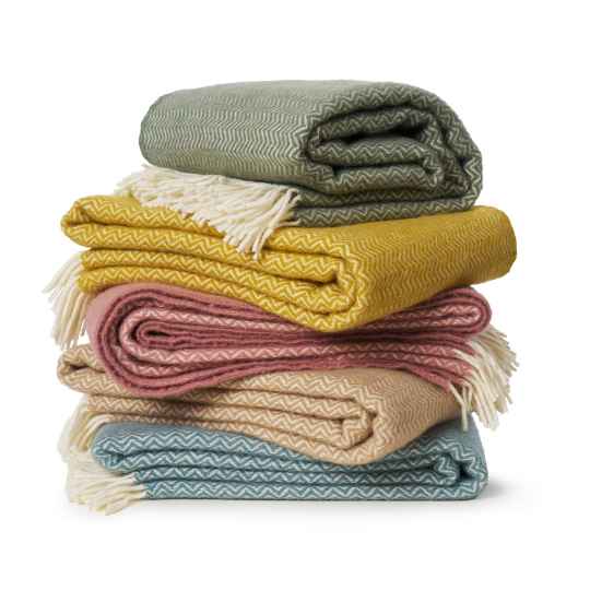 Stack of colorful folded blankets on a white background