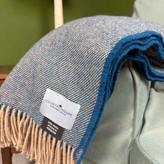 Blue and beige plaid blanket with a label on a chair