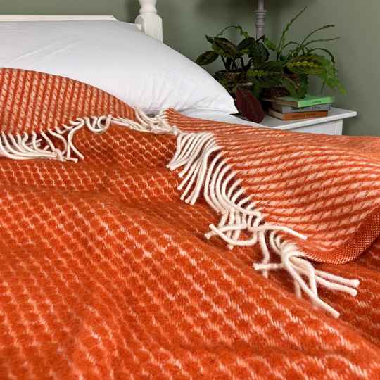 velvet rust wool throw  blanket on a bed showing both sides of the wool throw