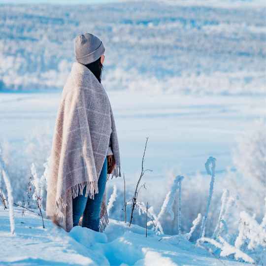 vinga island beige wool throw wrapped around a person in a snowy landscape