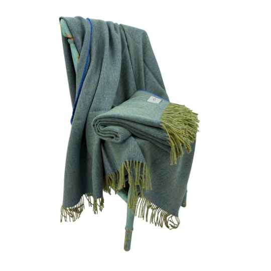 sky blue and lime recycled herringbone wool throw on a chair against a white background